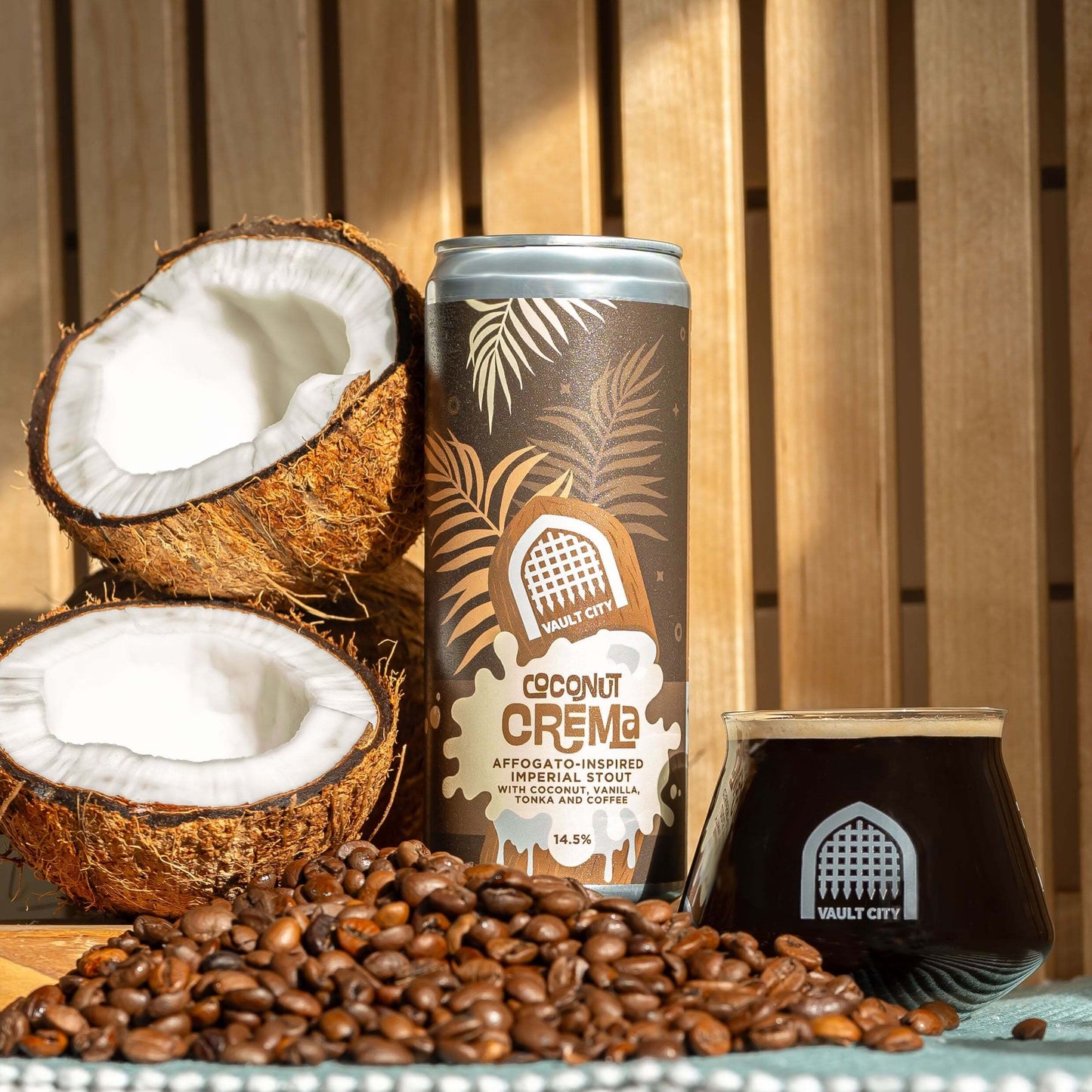 Coconut Crema Imperial Stout can and glass with coconuts and coffee beans on wooden surface.