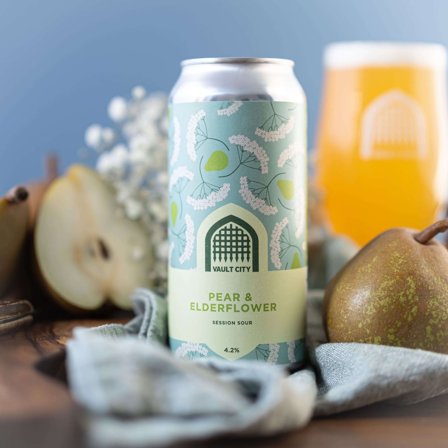 Pear & Elderflower Session Sour can with fresh pears and elderflower backdrop, showcasing sweet, tart, and fruity flavors.