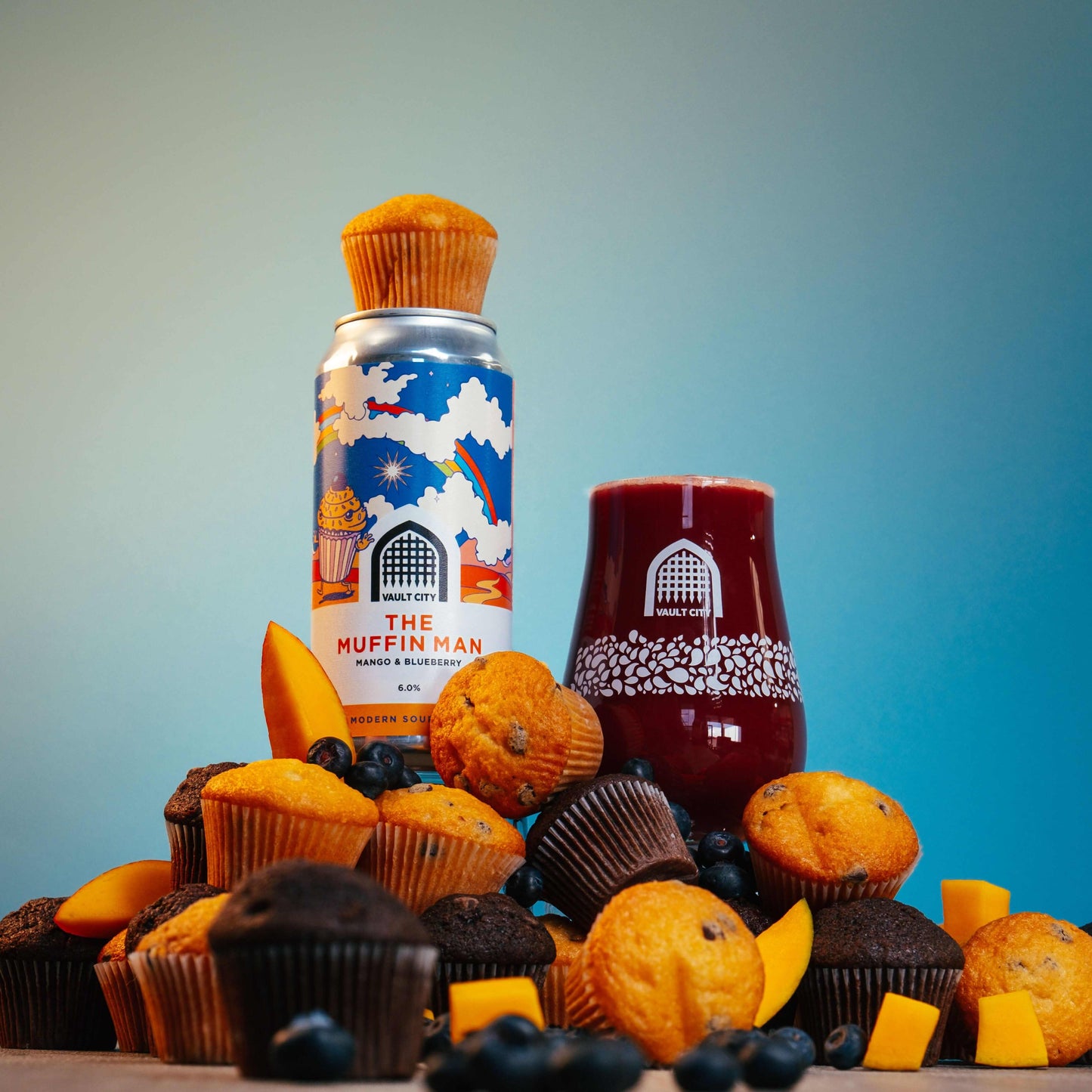 The Muffin Man Mango & Blueberry Muffins and Juice on Display with Fresh Mango Slices and Blueberries
