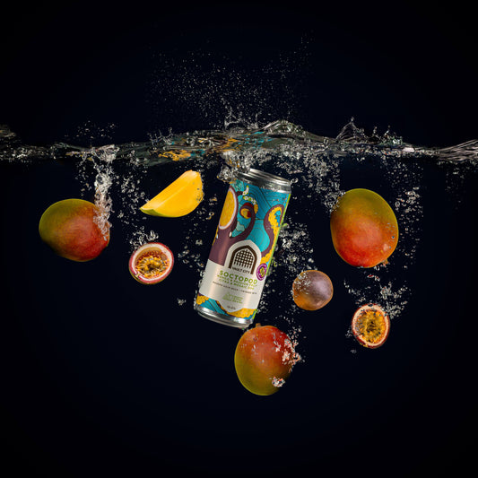 Soctopod DDH Citra & Mosaic Imperial Sour IPA can surrounded by floating passion fruits and Alphonso mangoes in water.