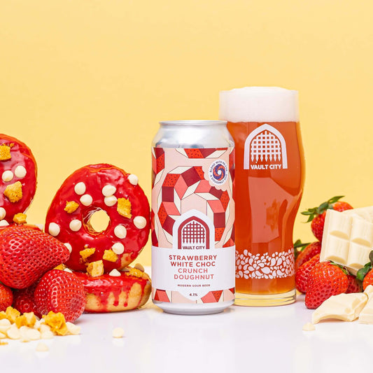 Strawberry White Choc Crunch Doughnut beer with glass, doughnuts, strawberries, and white chocolate on yellow background.