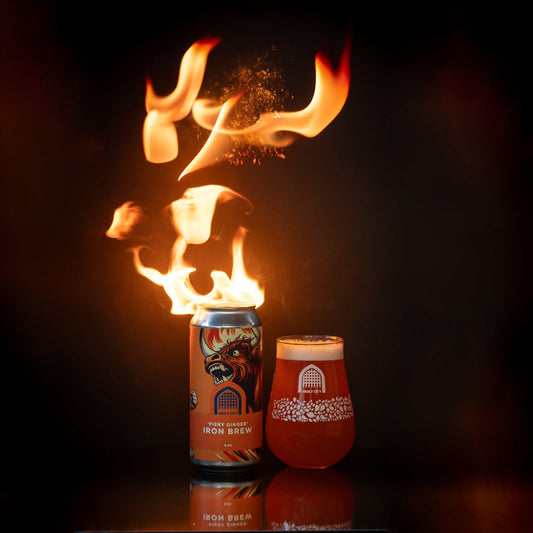 Fiery Ginger Iron Brew can and glass with flames, showcasing its bold and refreshing Scottish ginger beer flavor.